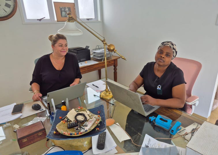People show peace signs at a demonstration with green ribbons and backdrop cranes.